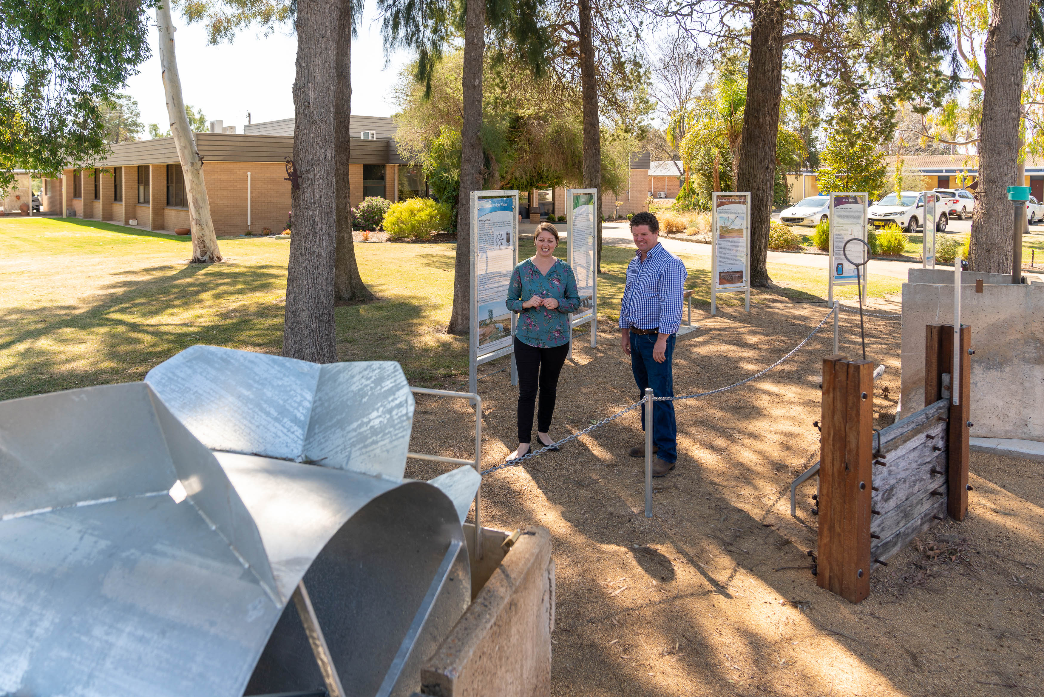 Male and female talking infront of Coleambally water wheel display