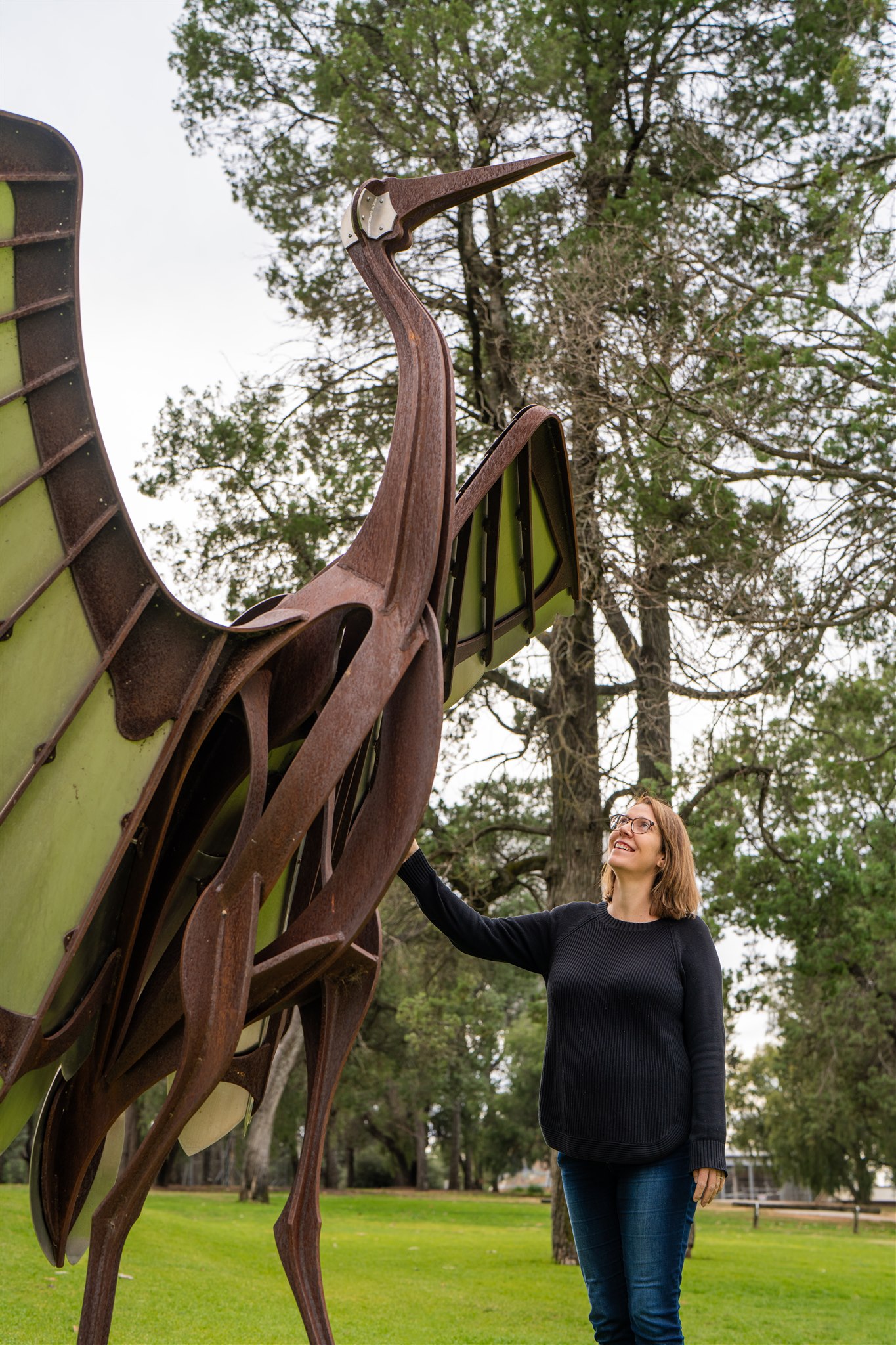 Woman looking at brolga sculpture